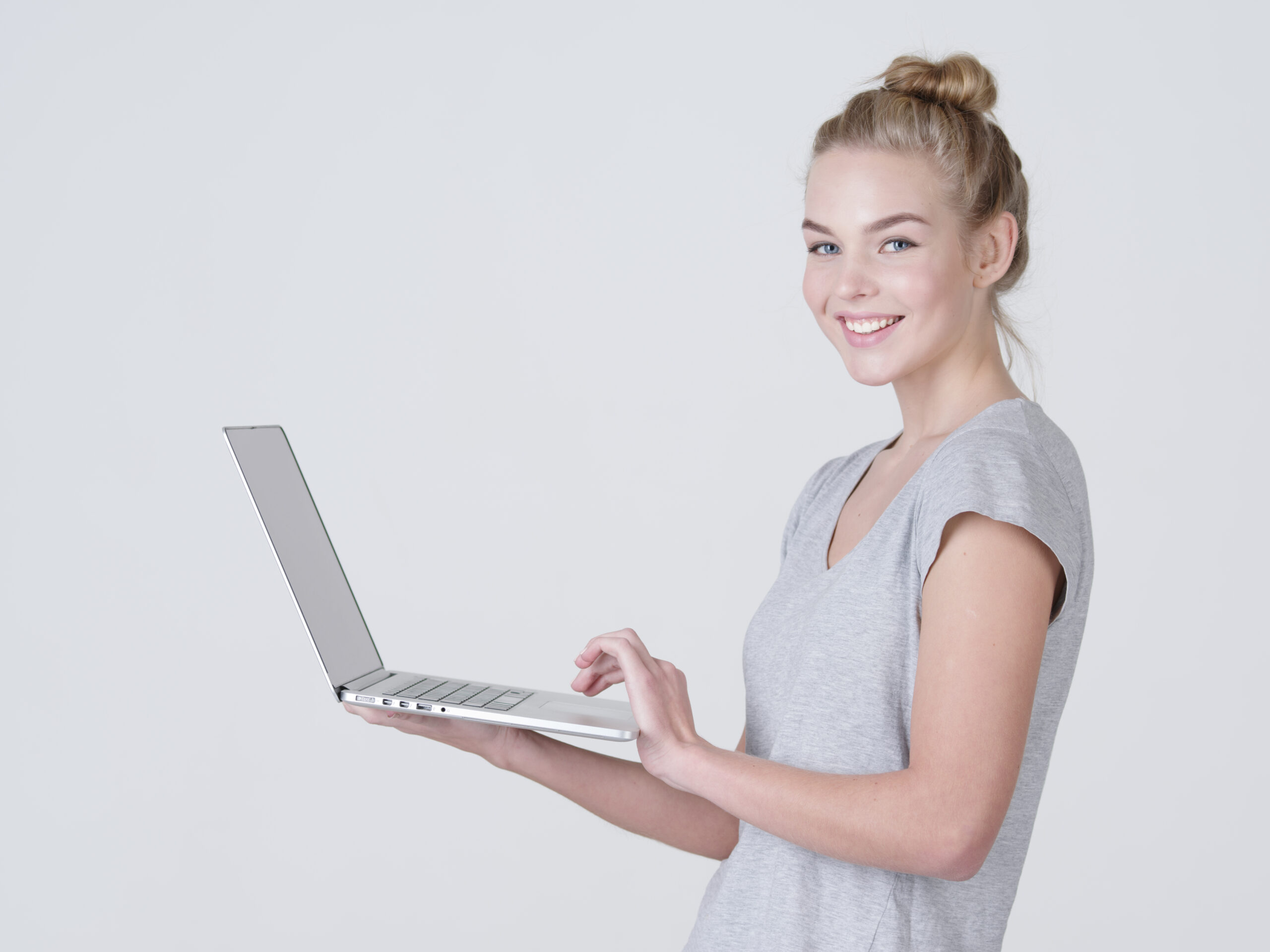 Young woman holds laptop in habds.